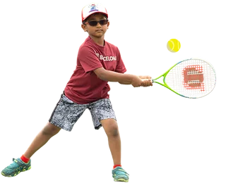 Boy with cap and sunglasses about to hit a tennis ball with his racket